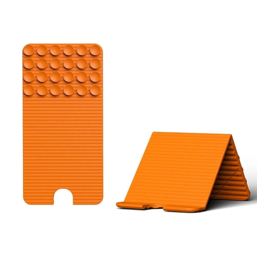 Versatile Foldable Silicone Suction Stand – Universal Adhesive Grip Pad for Phone, Tablet, and Laptop, Bendable Multi-Surface Mount for Desk, Mirror, Gym, and Travel (Orange)